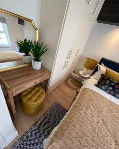 een kamer met 2 bedden, een tafel en een spiegel bij 52 Lansdown Crescent in Cheltenham