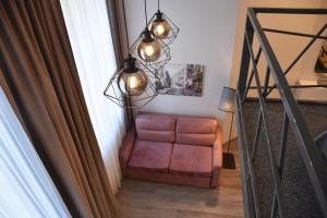 un fauteuil en cuir brun dans une chambre avec fenêtre dans l'établissement Familia Apartments, à Vilnius