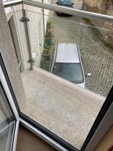 a white car parked in a street outside a window at CASA MONTEVIDEU in Mirandela
