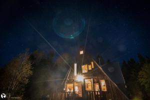 Una casa iluminada por la noche con luces encendidas en Au Sommet du Fjord en Sacré-Coeur-Saguenay