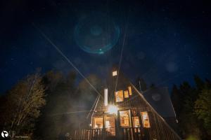 una casa illuminata di notte con luci sopra di Au Sommet du Fjord a Sacré-Coeur