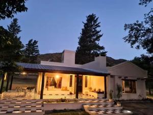 ein weißes Haus mit einem Tisch und Stühlen davor in der Unterkunft las brisas casas de campo un lugar para soñar in San Antonio de Arredondo