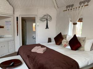 a bedroom with a large bed with towels on it at Karoo Soul in Oudtshoorn +53 photos
