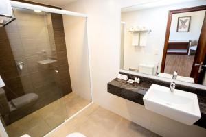 a bathroom with a sink and a glass shower at Alta Reggia Plaza Hotel in Curitiba +26 photos