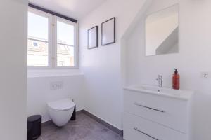 a white bathroom with a toilet and a sink at 175SQM HIGH-END Luxury Apartment - Heart Of Copenhagen in Copenhagen