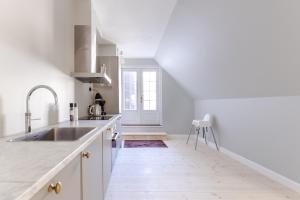 a white kitchen with a sink and a counter at 175SQM HIGH-END Luxury Apartment - Heart Of Copenhagen in Copenhagen