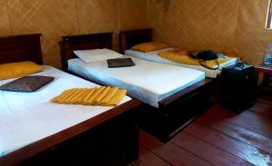 a group of three beds in a room at Tree house Hostel Sigiriya in Sigiriya
