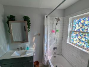 a bathroom with a tub and a sink and a window at eKstasis Hostel & Urban Farm in Atlanta