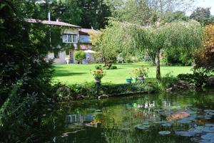 a garden with a pond in front of a house at Ferienwohnung Hummel in Bad Buchau