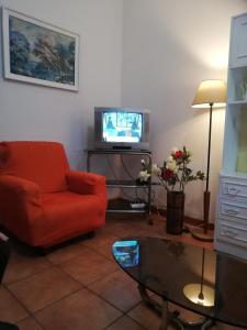 a living room with a red chair and a television at Apartamento Tiago in Sines