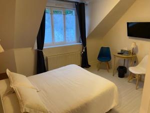 a bedroom with a white bed and a window at Le Cancalais in Cancale