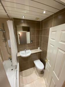 a bathroom with a toilet, sink, and shower at Lost Guest House Stirling in Stirling