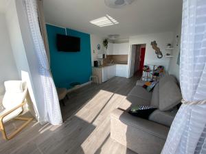 a living room with a gray couch and a blue wall at Studio front de mer 'Le Soleillan' in La Grande Motte