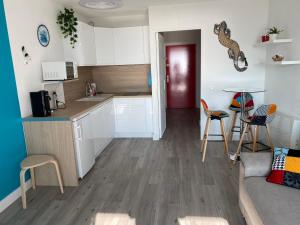 una cucina e un soggiorno con tavolo e sedie di Studio front de mer 'Le Soleillan' a La Grande-Motte