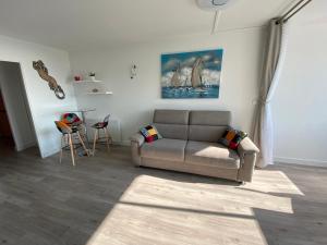 un soggiorno con un divano e un tavolo di Studio front de mer 'Le Soleillan' a La Grande-Motte