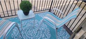 Un balcón con una mesa, una silla y una planta en Cozy Tri-level Townhouse - 3 min from Outdoor Mall at Partridge Creek en Waldenburg