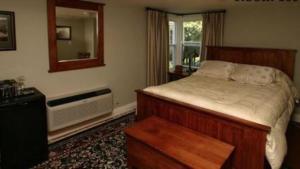 Schlafzimmer mit einem Bett, einem Spiegel und einem Fenster in der Unterkunft Bayside Inn in Parry Sound