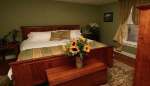 een slaapkamer met een bed met een vaas met bloemen bij Bayside Inn in Parry Sound
