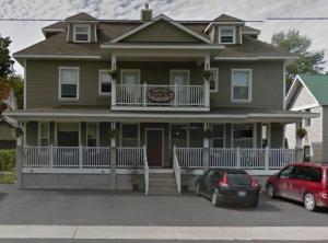 a house with two cars parked in front of it at Bayside Inn in Parry Sound