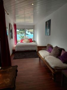 sypialnia z łóżkiem, kanapą i oknem w obiekcie Villa des Galets w mieście Saint-Pierre