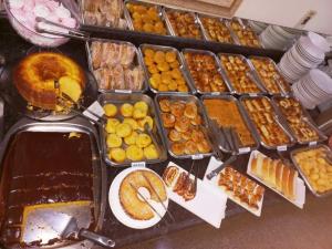a bunch of trays filled with different types of food at Hotel Graunas in São Carlos