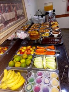 a buffet filled with lots of different fruits and vegetables at Hotel Graunas in São Carlos