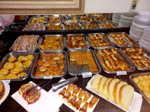 a buffet of different types of pastries and bread at Hotel Graunas in São Carlos
