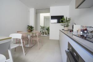 a kitchen and dining room with a table and chairs at Kalibia rooms and suites in Mazara del Vallo