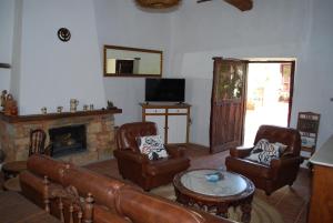 sala de estar con muebles de cuero y chimenea en Los Polvazares, en Castrillo de los Polvazares