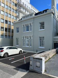 une voiture blanche garée dans un parking en face d'un bâtiment dans l'établissement Lovely 1 Bed flat *FREE PARKING* Hoe/Barbican Plymouth, à Plymouth