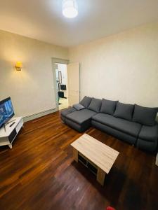a living room with a couch and a coffee table at Appartement proche de la ville et du parc du Truchet in Saint-Claude