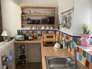 een keuken met een wastafel en een aanrecht bij Honeysuckle Cottage in Kingsbridge
