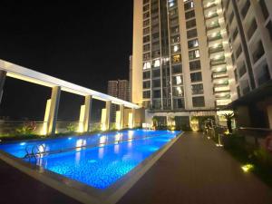 a large swimming pool in the middle of a building at night at Luxury Apartment Asiana Capella Trung tâm Chợ lớn in Ho Chi Minh City