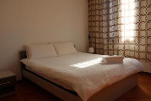 Schlafzimmer mit einem Bett mit weißer Bettwäsche und einem Fenster in der Unterkunft b&b Wu Giada in Mestre