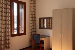 Zimmer mit einem Schreibtisch, einem Stuhl und einem Fenster in der Unterkunft b&b Wu Giada in Mestre