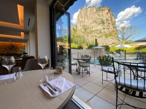 um restaurante com mesas e cadeiras e vista para uma montanha em Nouvel Hôtel du Commerce em Castellane