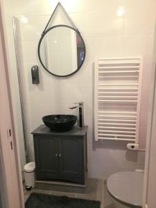 uma casa de banho com um lavatório preto e um espelho em Les Roches Restaurant & Chambre d'Hotes em Servant