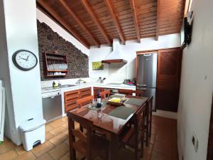 a kitchen with a table and a refrigerator at La Fortaleza in Erjos-El Tanque