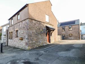 an old brick building with a door on a street at Summerseat in Kirkby Stephen