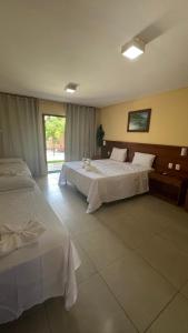 um quarto de hotel com duas camas e uma janela em Sol e Mar - AP 05 - Be Summer em Flecheiras