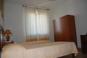 sypialnia z łóżkiem i drewnianą szafką w obiekcie C'e Posto Per Te w mieście SantʼAntìoco