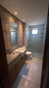 a bathroom with a sink and a toilet and a mirror at AP 05 com Jacuzzi - Sol e Mar Residence Be Summer in Flecheiras +22 photos