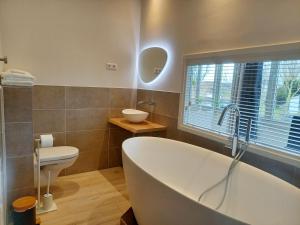 Pura Vida del Rio في Oud-Ade: حمام مع حوض استحمام ومرحاض ومغسلة +41 صورة