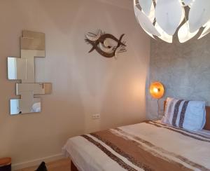 Pura Vida del Rio في Oud-Ade: غرفة نوم بسرير وثريا