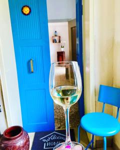 a glass of white wine sitting next to a blue door at Polly's Verona Apartment in Verona