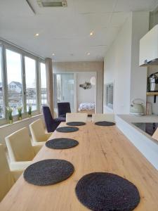 Pura Vida del Rio في Oud-Ade: طاولة خشبية كبيرة عليها أربع سجادات سوداء كبيرة