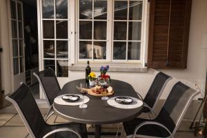 un tavolo e sedie neri con bicchieri da vino e fiori di Chalet Spitzhorn - Your Peak Getaway - Private Terrasse & gratis Parkplatz a Gsteig
