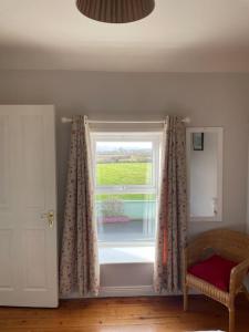 a window with curtains and a chair in a room at Drumville House Self Catering in Castlemaine