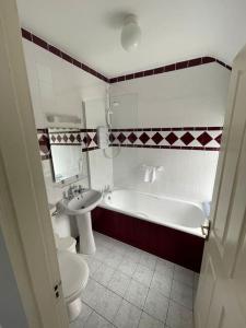 a bathroom with a toilet and a tub and a sink at Drumville House Self Catering in Castlemaine