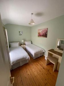 a room with two beds and a desk and a piano at Drumville House Self Catering in Castlemaine